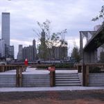 "View of newly built park deck and Manhattan skyline from Fulton Ferry Landing. Includes World Trade Center towers, Woolworth building, and Brooklyn Bridge."